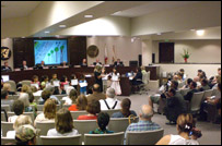 Photo of board chambers with winnders in the foreground and audience in the background